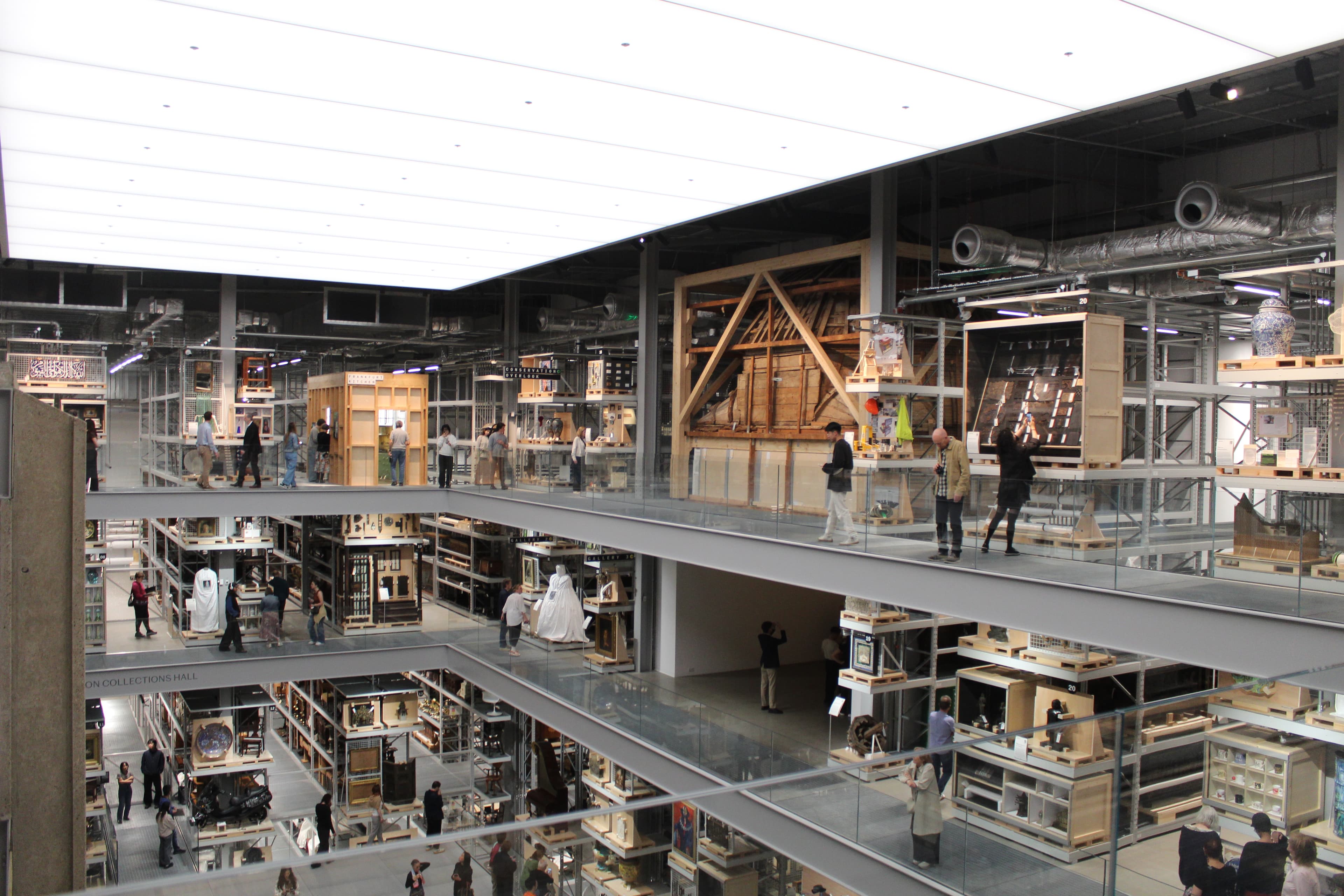 从 V&A East Storehouse 三层俯瞰 Collections Hall,一件大型木结构放在托盘上,三个楼层的走道上都有参观者。