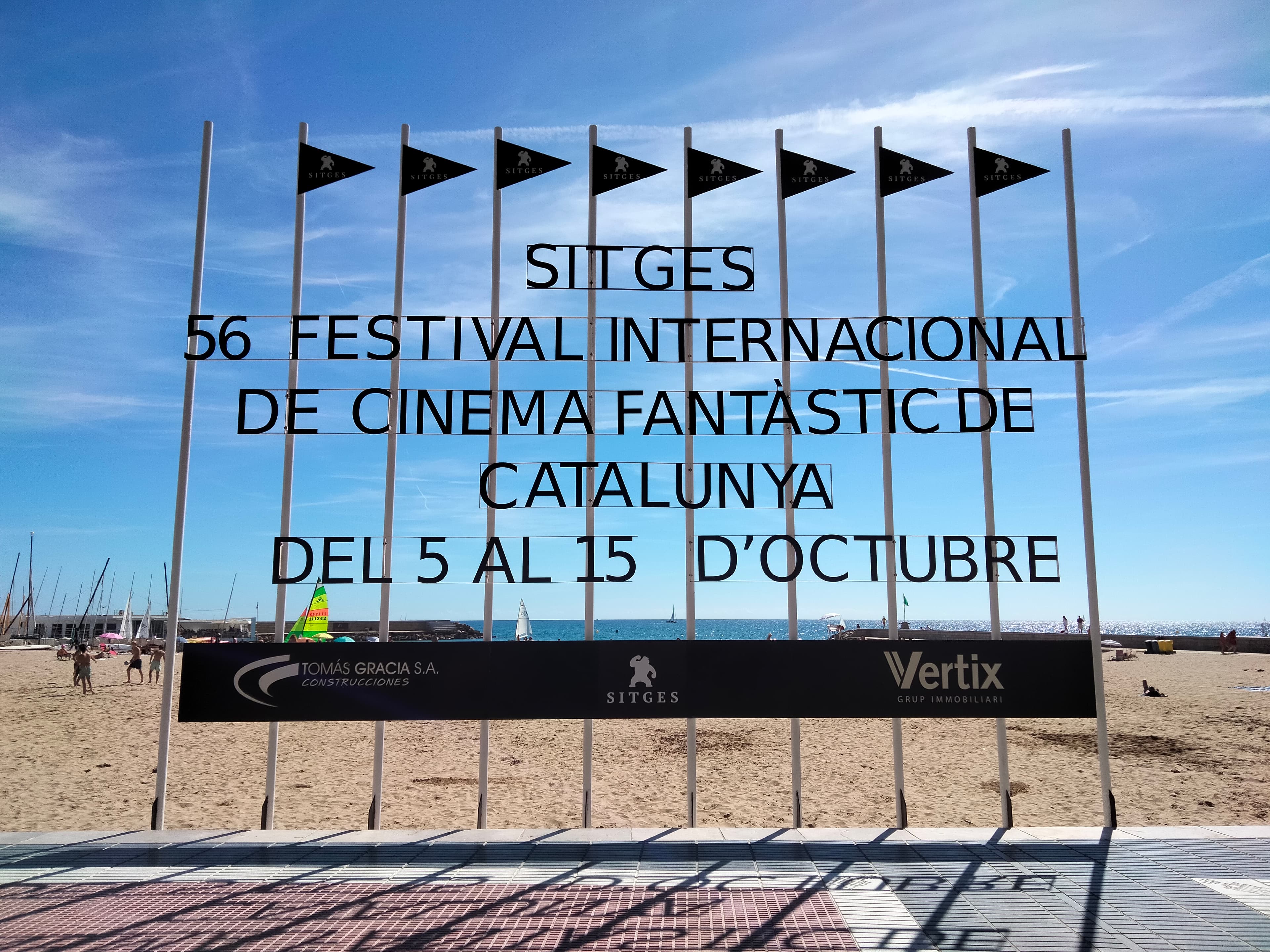A large festival banner for the Sitges International Fantastic Film Festival mounted on the seafront promenade at Passeig de la Ribera.