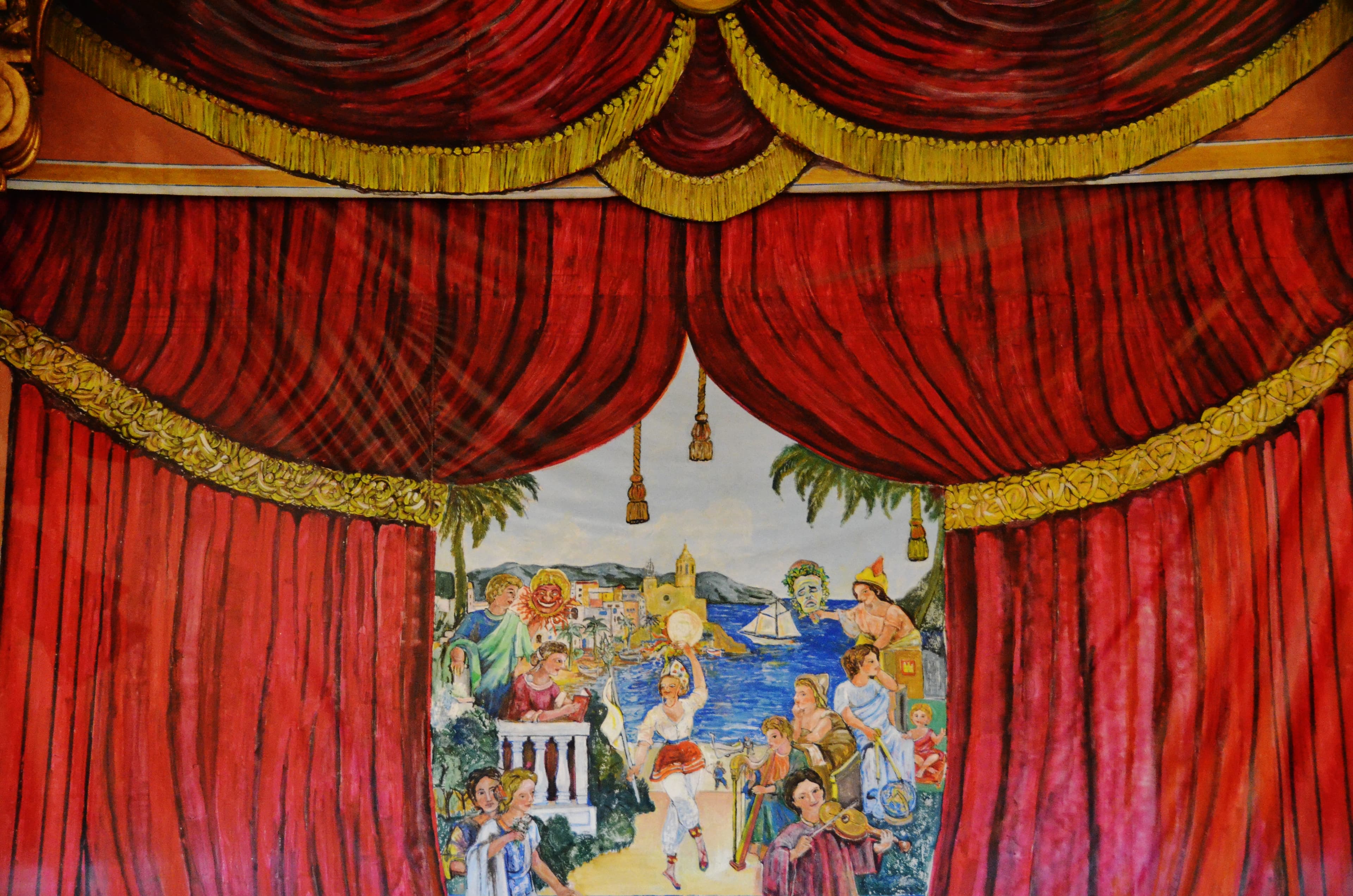 Il palcoscenico del Casino Prado Suburense a Sitges, con decorazione dipinta sul boccascena e file di poltrone.