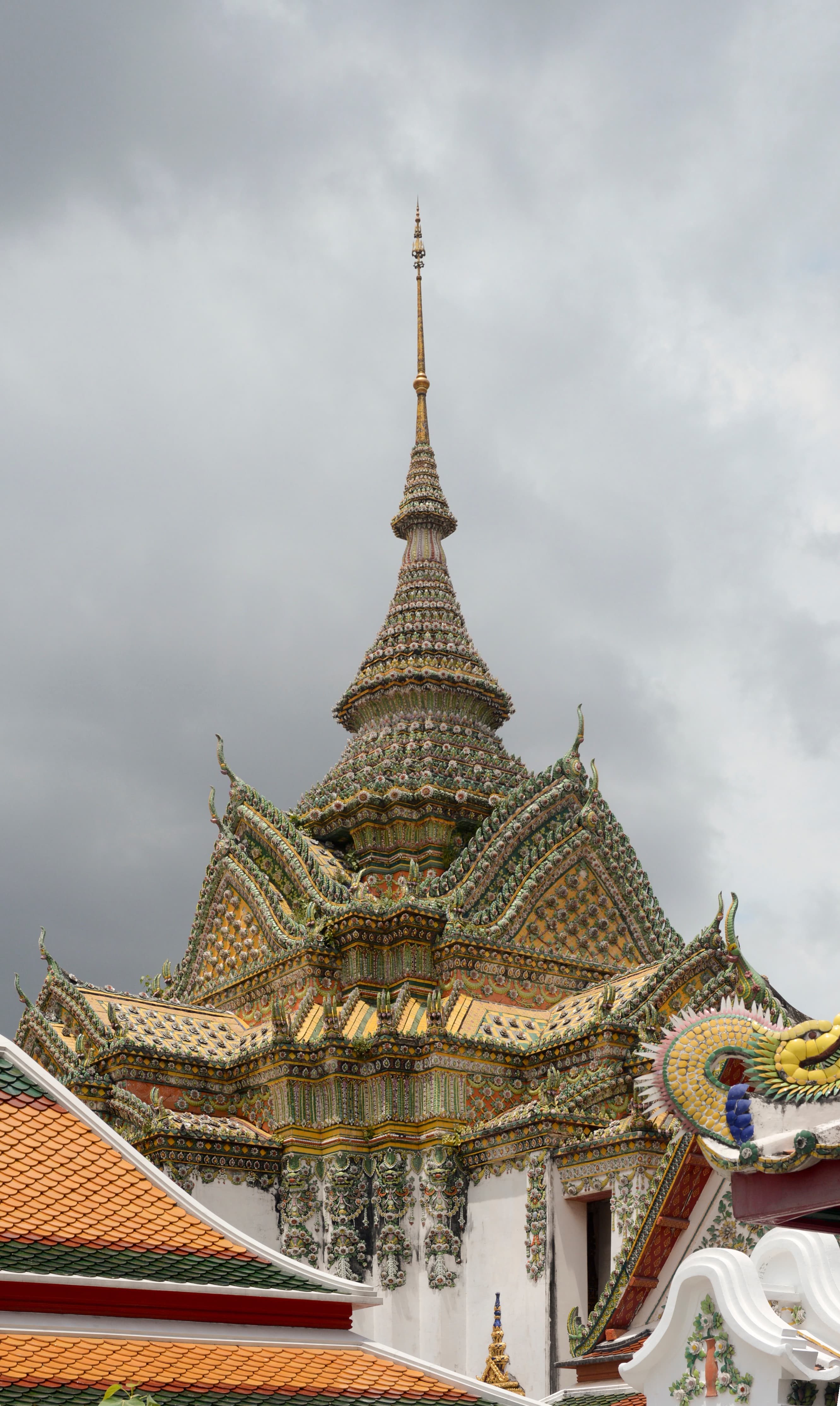 A courtyard view within Wat Pho temple complex in Bangkok, with ornate spires and covered walkways.