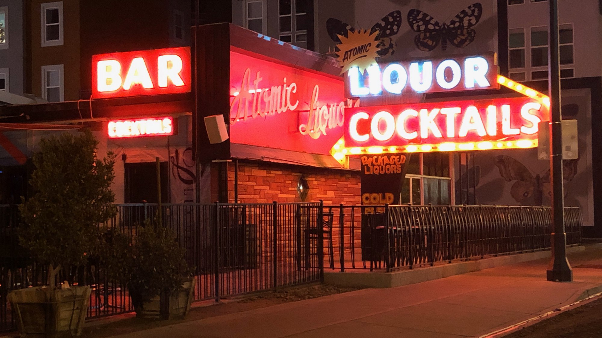 Atomic Liquors' corner neon sign lit up at night on Fremont Street, Las Vegas