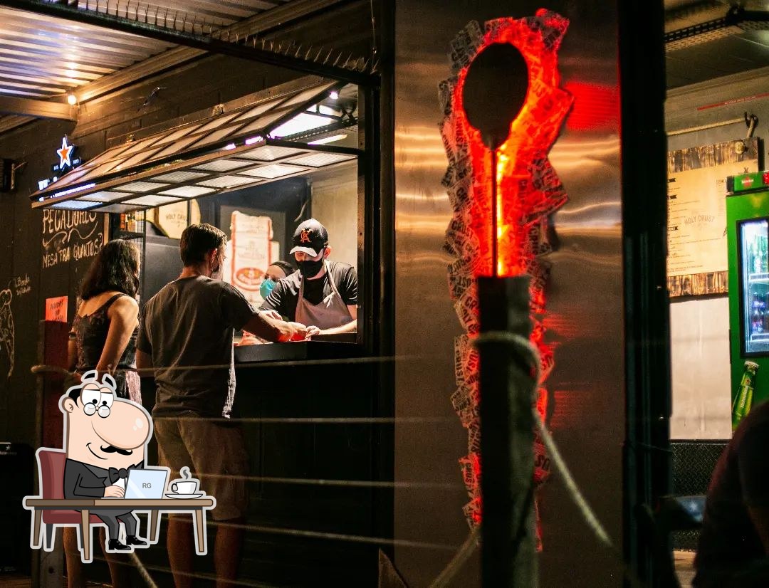Il bancone e l'allestimento stile food-truck di Holy Crust, São Carlos, di sera